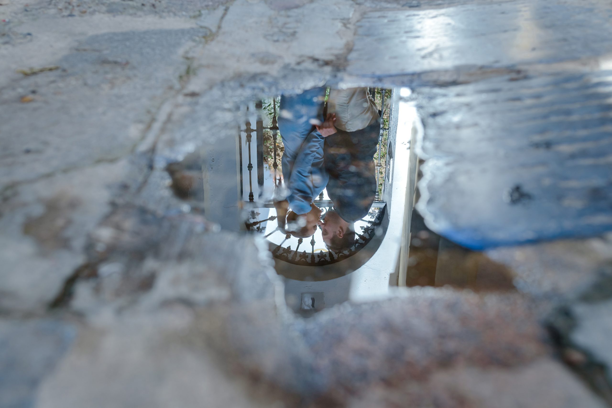 Reflejo de los novios besándose en un charco