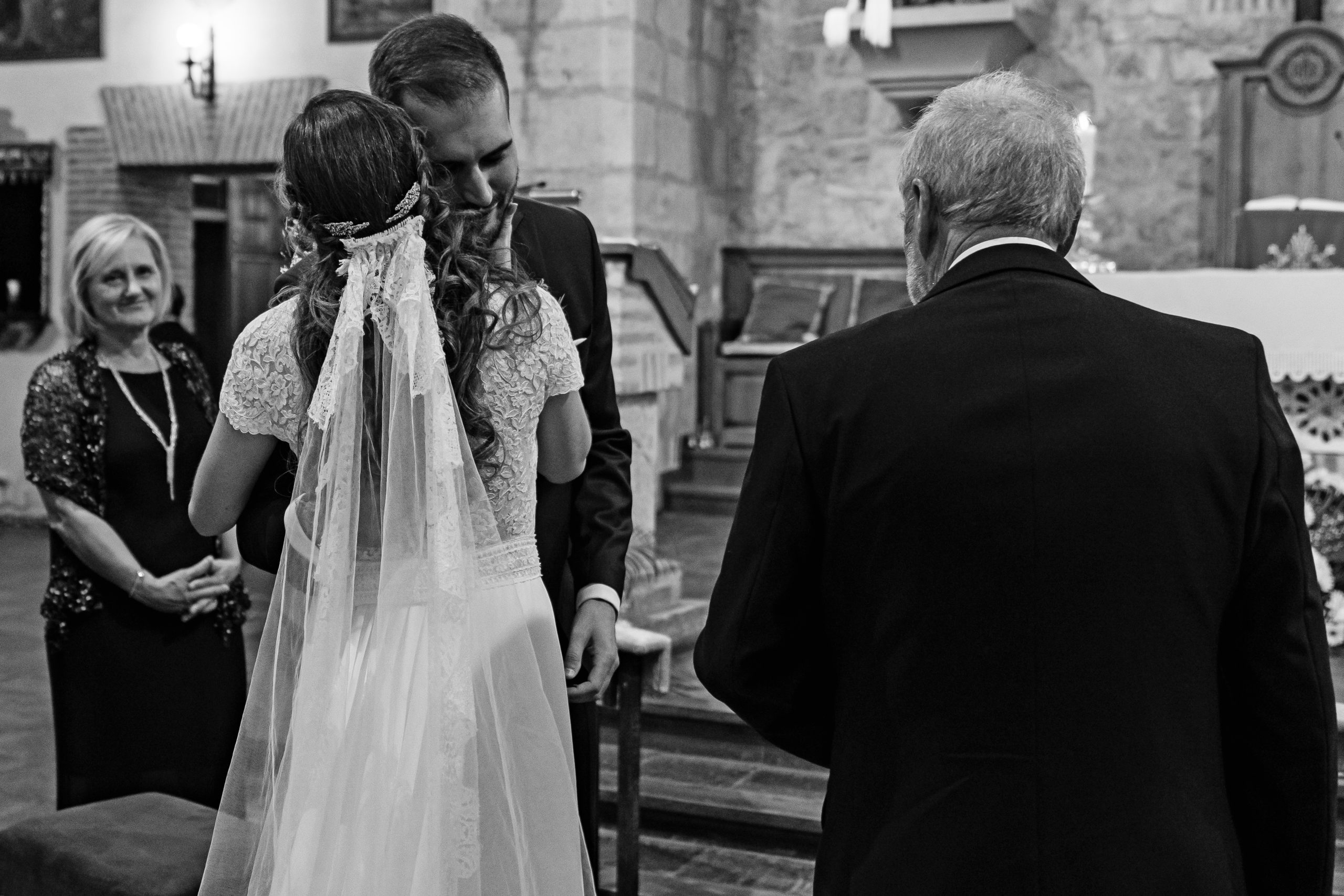 Foto en blanco y negro de los novios abrazándose nada más llegar al altar