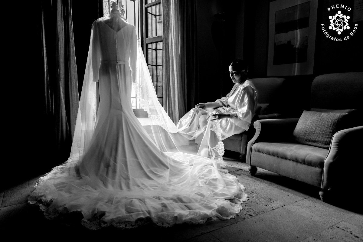 Fotografía en blanco y negro de la novia mirando su vestido