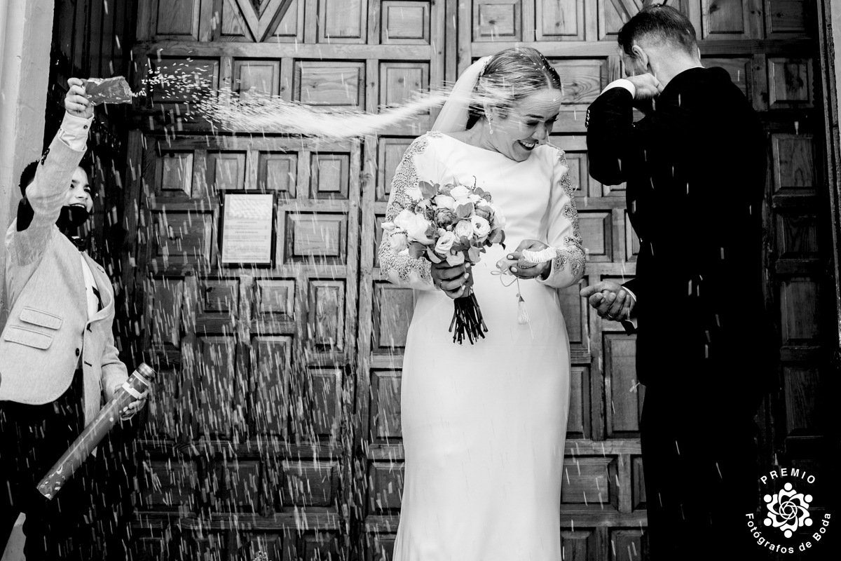 Fotografía en blanco y negro de una pareja saliendo de la boda
