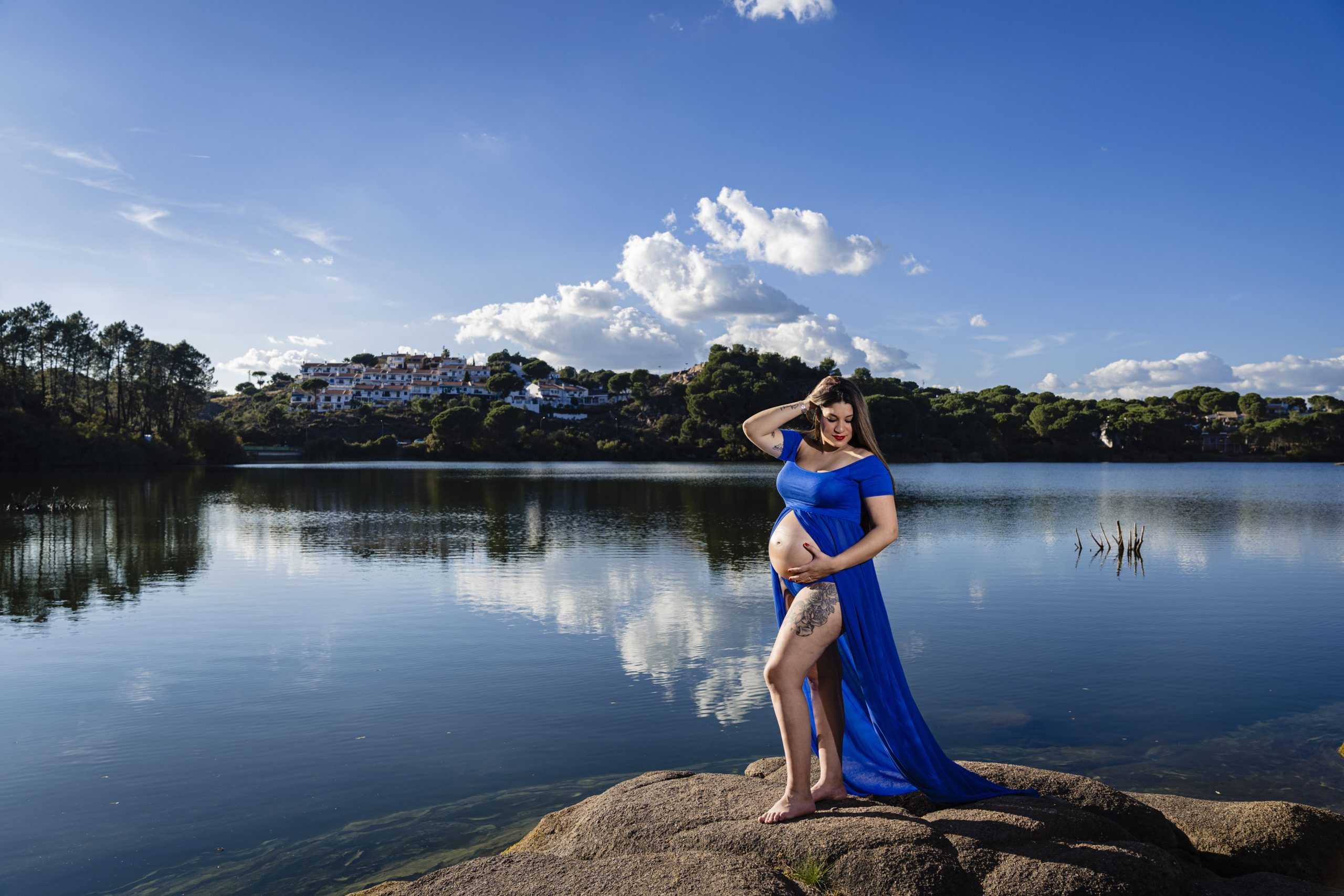Embarazada acariciando su barriga a la orilla del río