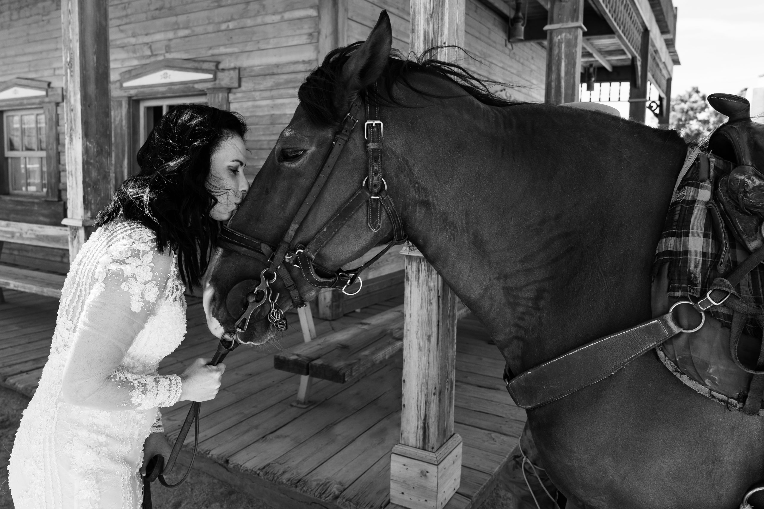 Fotografía en blanco y negro de la novia dando un beso a un caballo