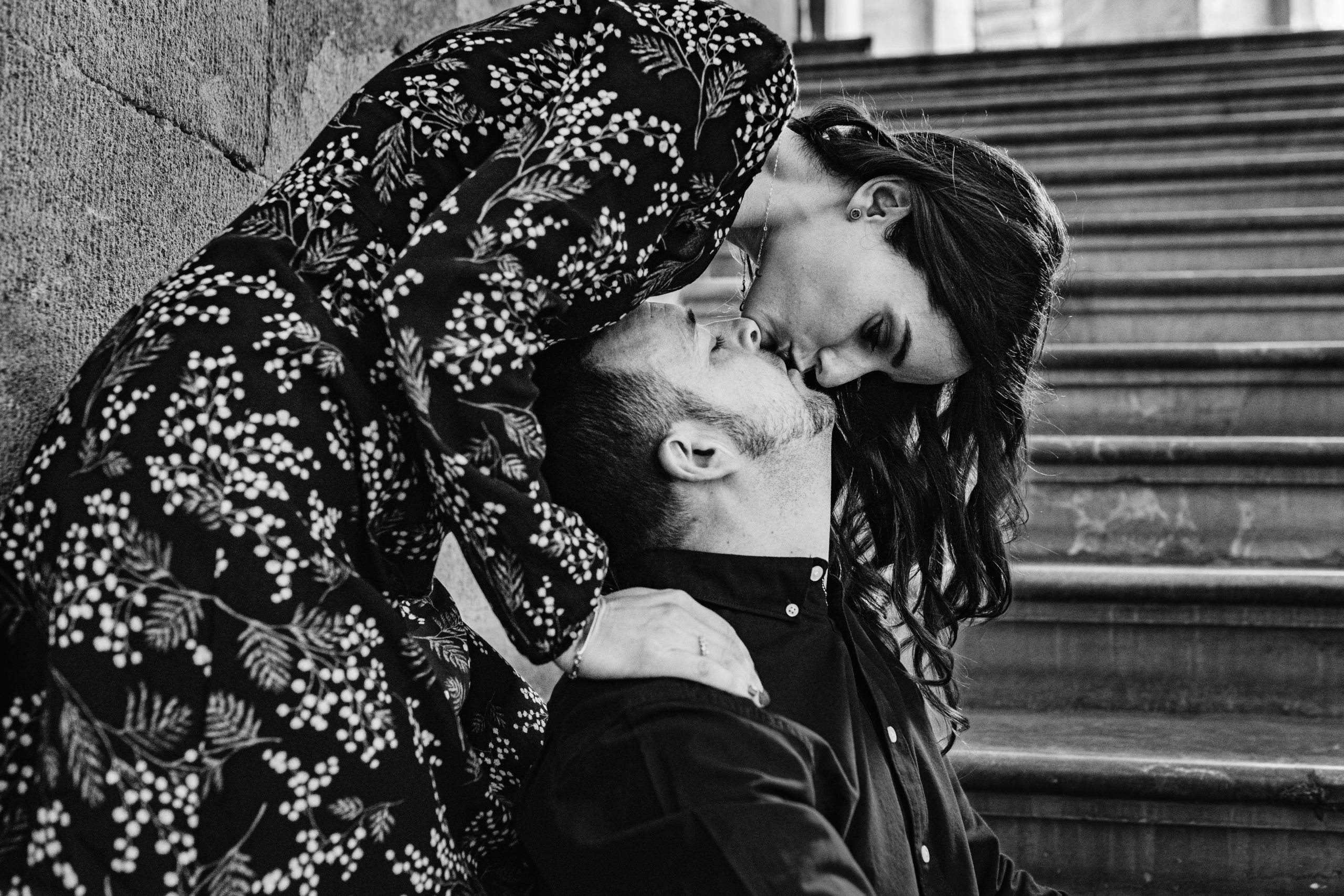 Fotografía en blanco y negro de una pareja besándose en unas escaleras
