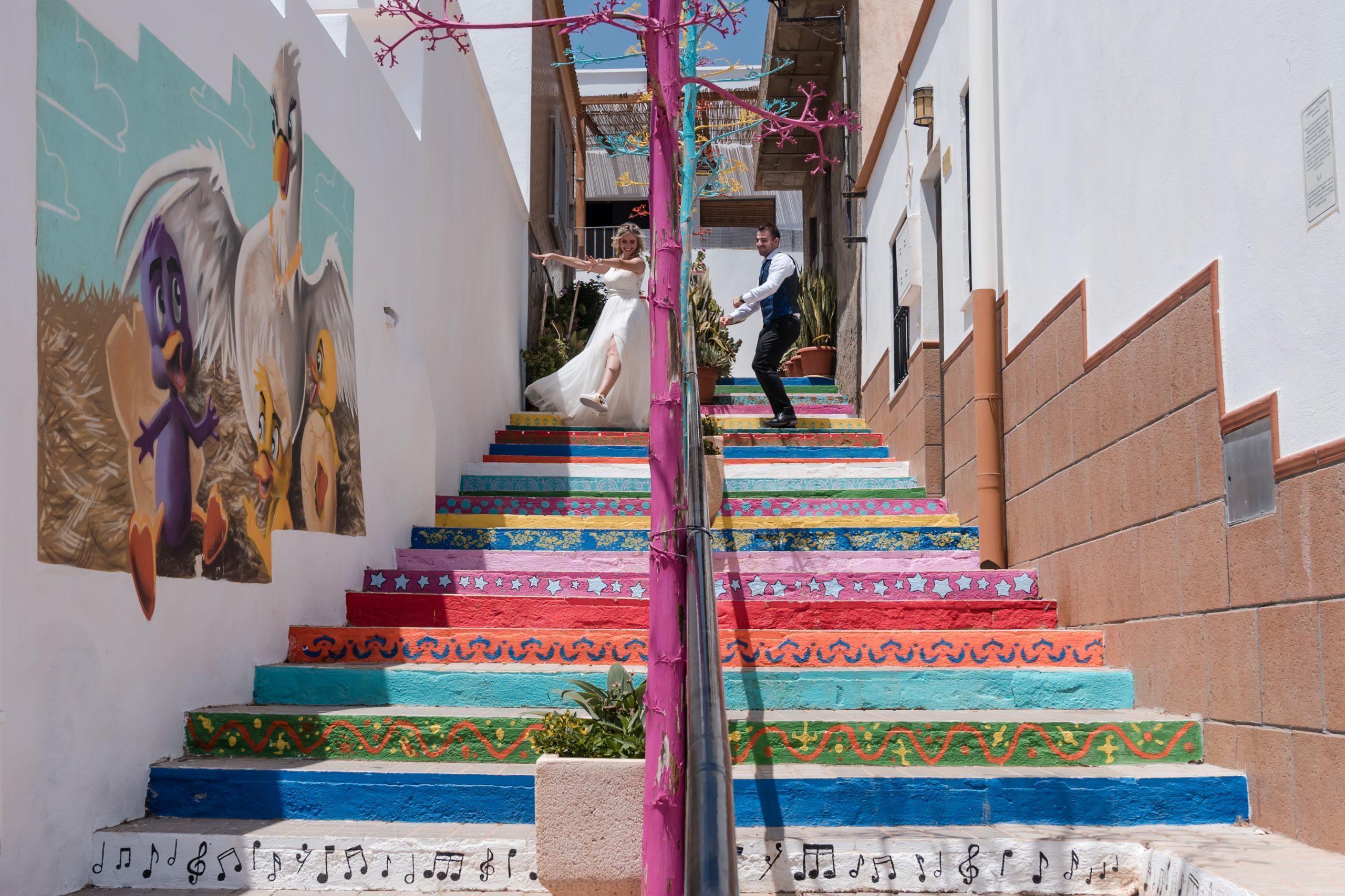 Novios bajando las escaleras coloridas felices