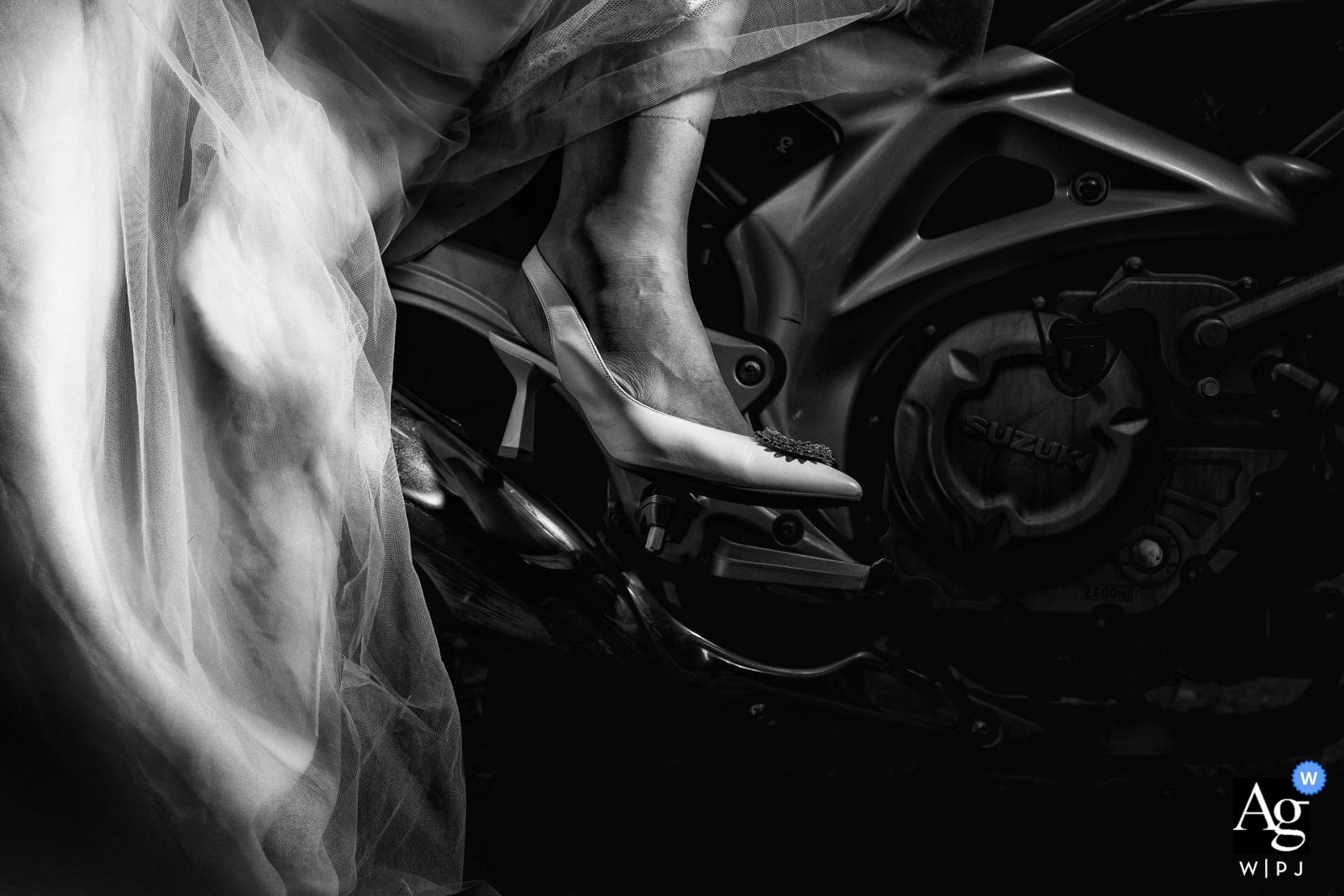 Fotografía en blanco y negro de un tacón sobre una moto suzuki