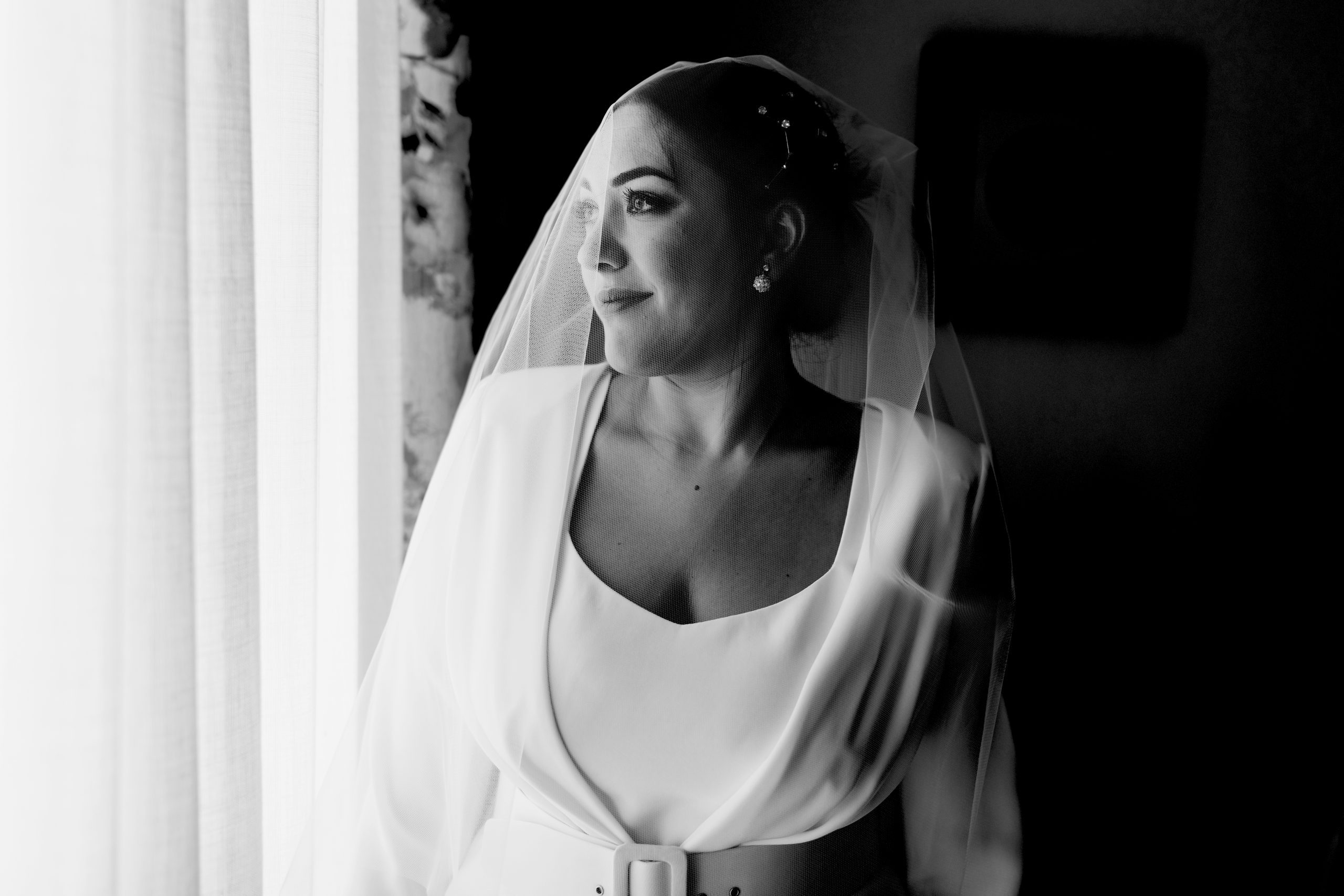 Fotografía en blanco y negro de la novia mirando por la ventana