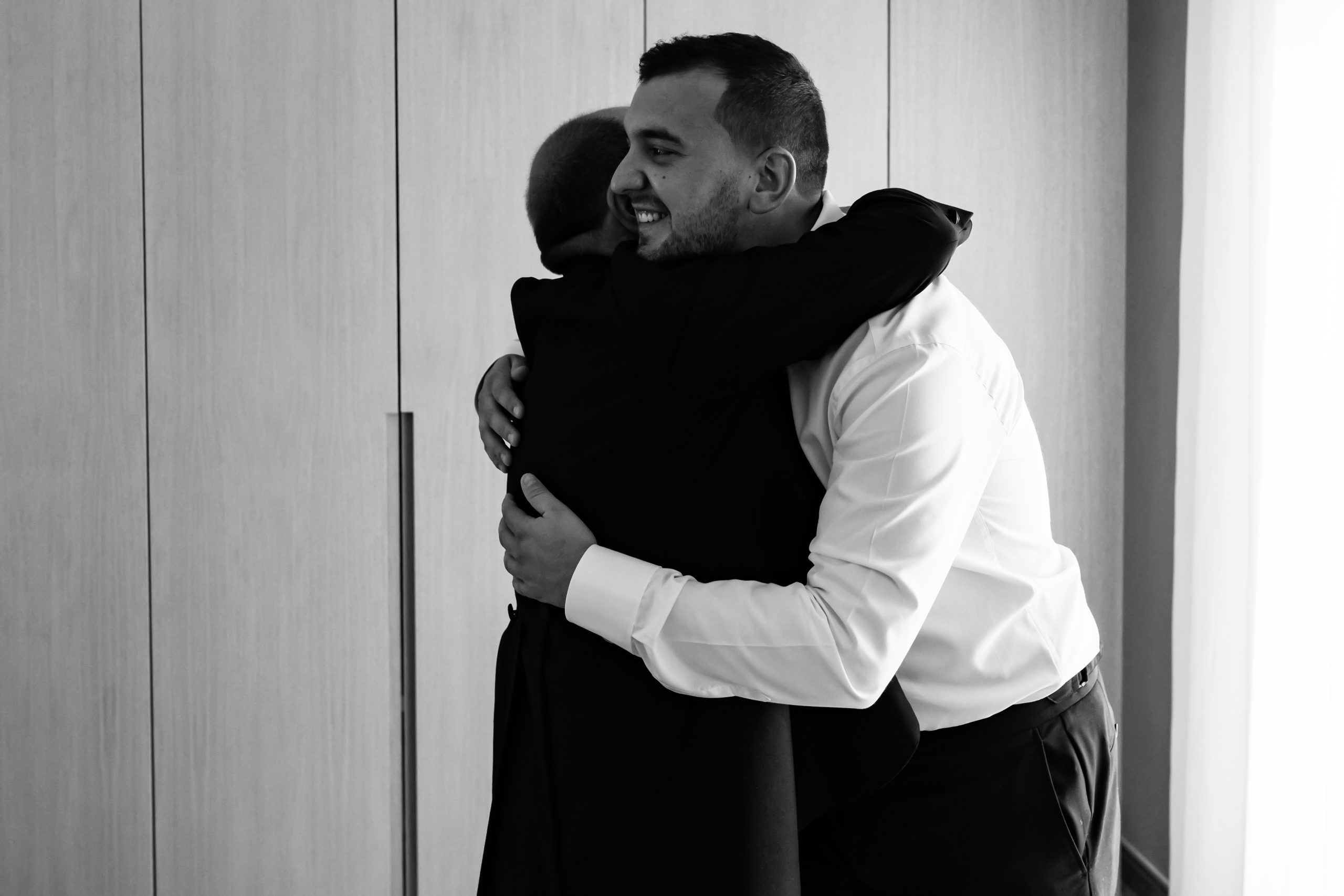 Fotografía en blanco y negro de unos hombres abrazándose