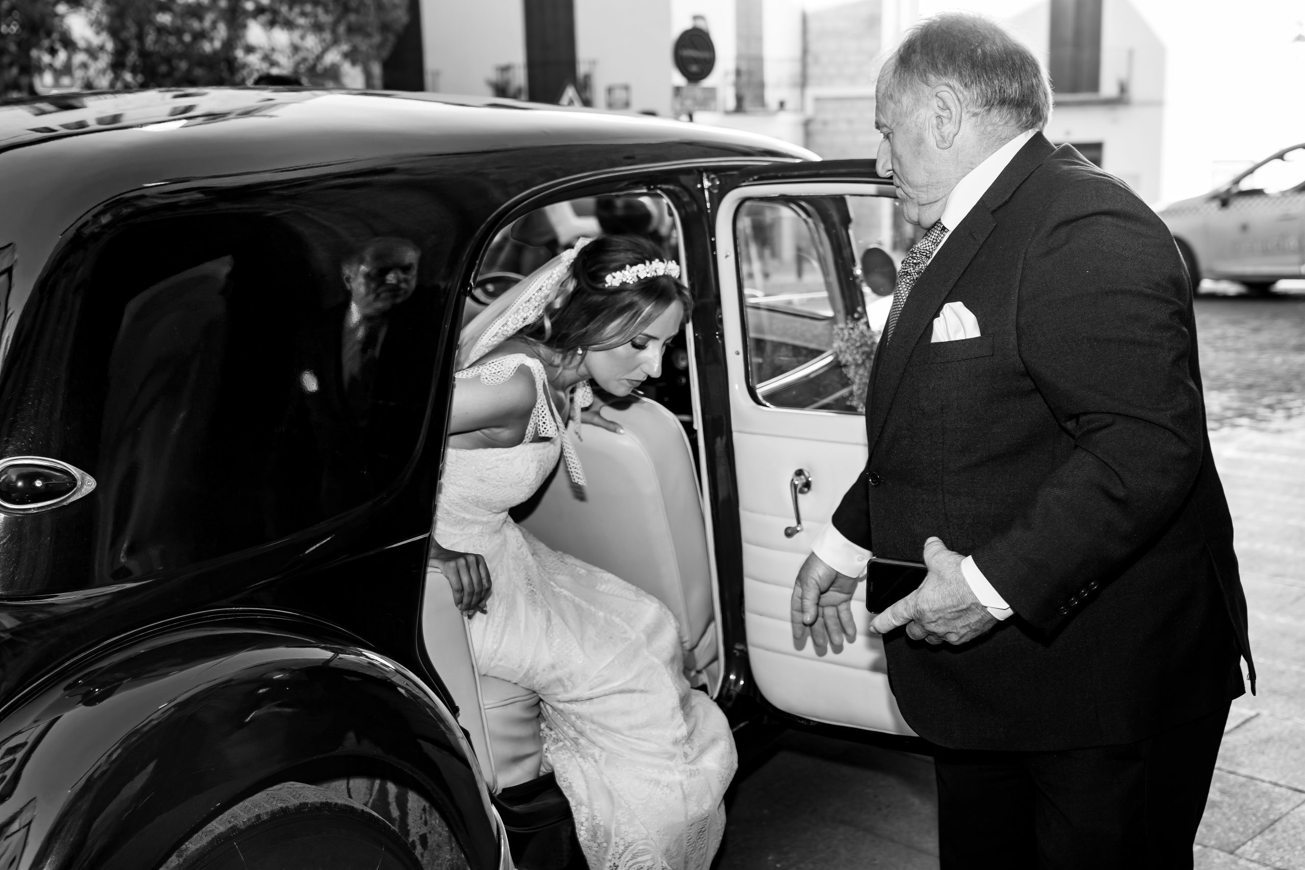 Fotografía en blanco y negro de la novia saliendo del coche