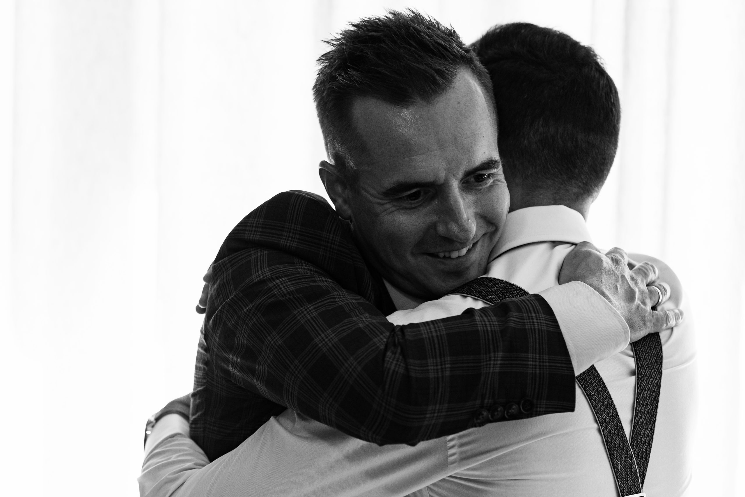 fotografía en blanco y negro de dos hombres abrazándose