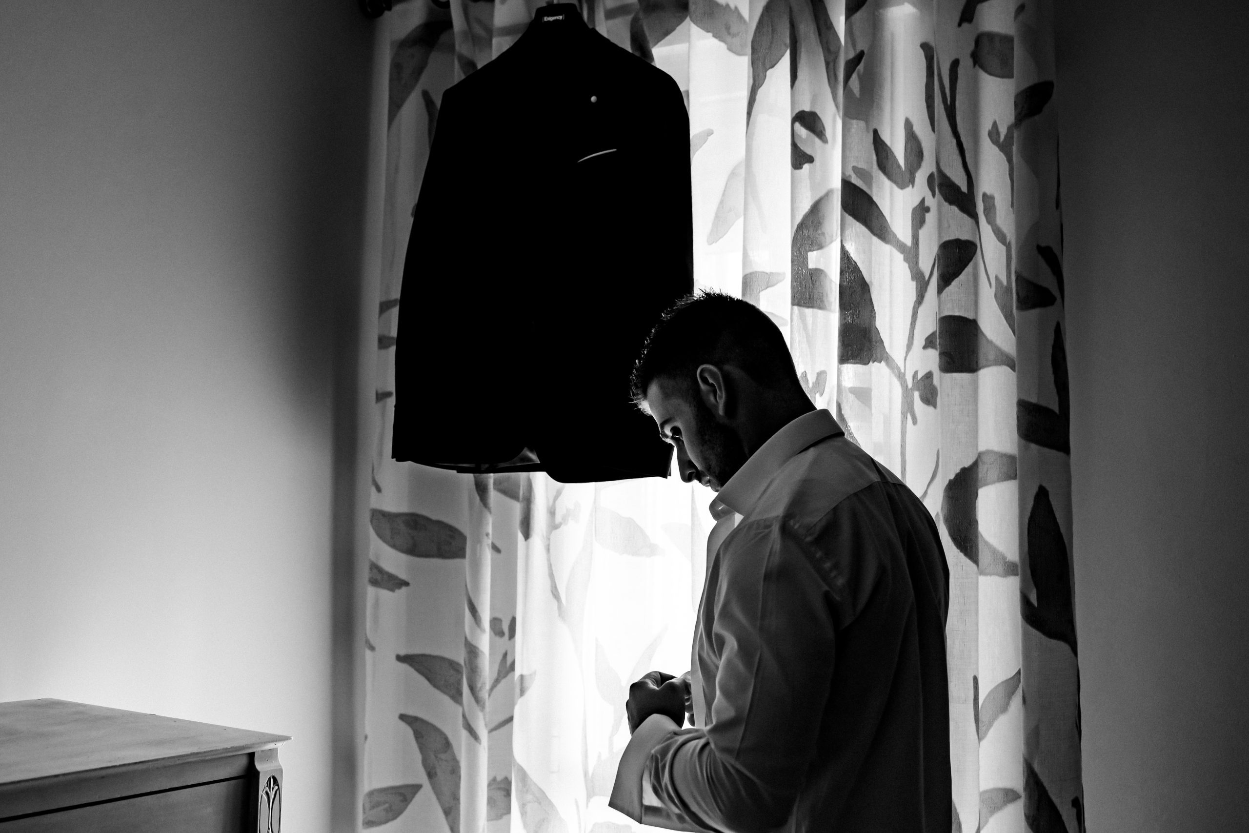 Fotografía en blanco y negro del novio preparandose
