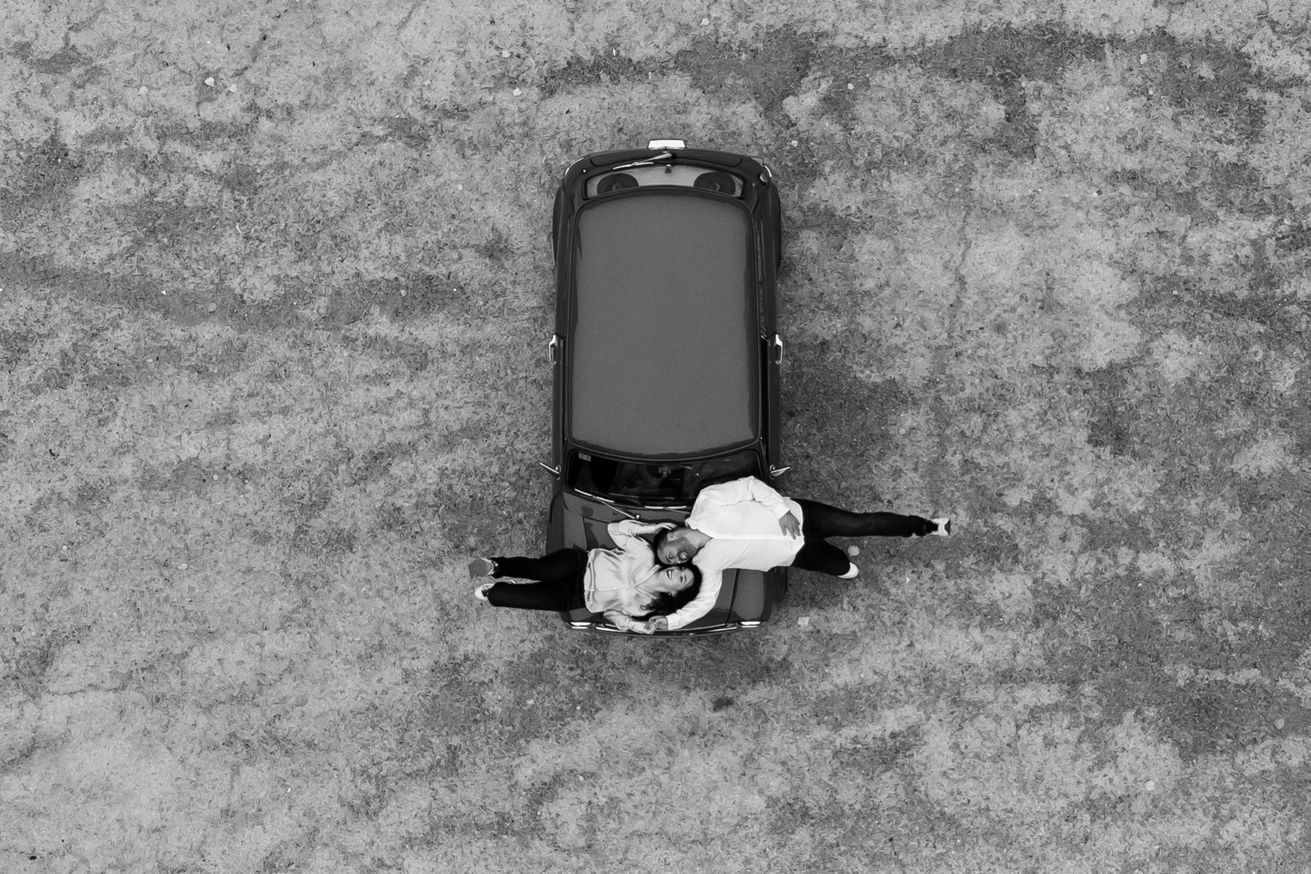 Fotografía en blanco y negro de una pareja sobre un coche