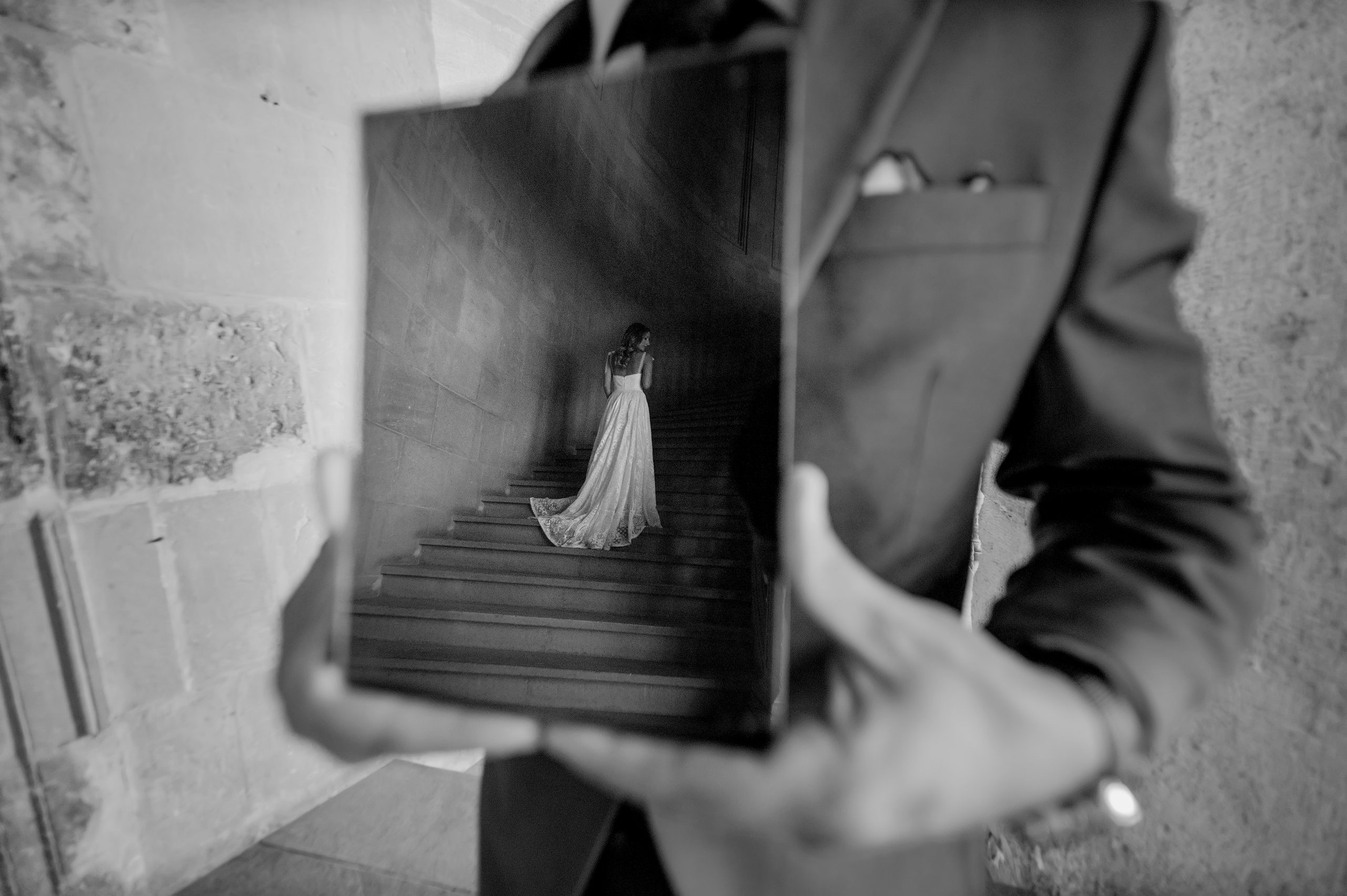 Reflejo en un espejo de una novia de espaldas subiendo las escaleras
