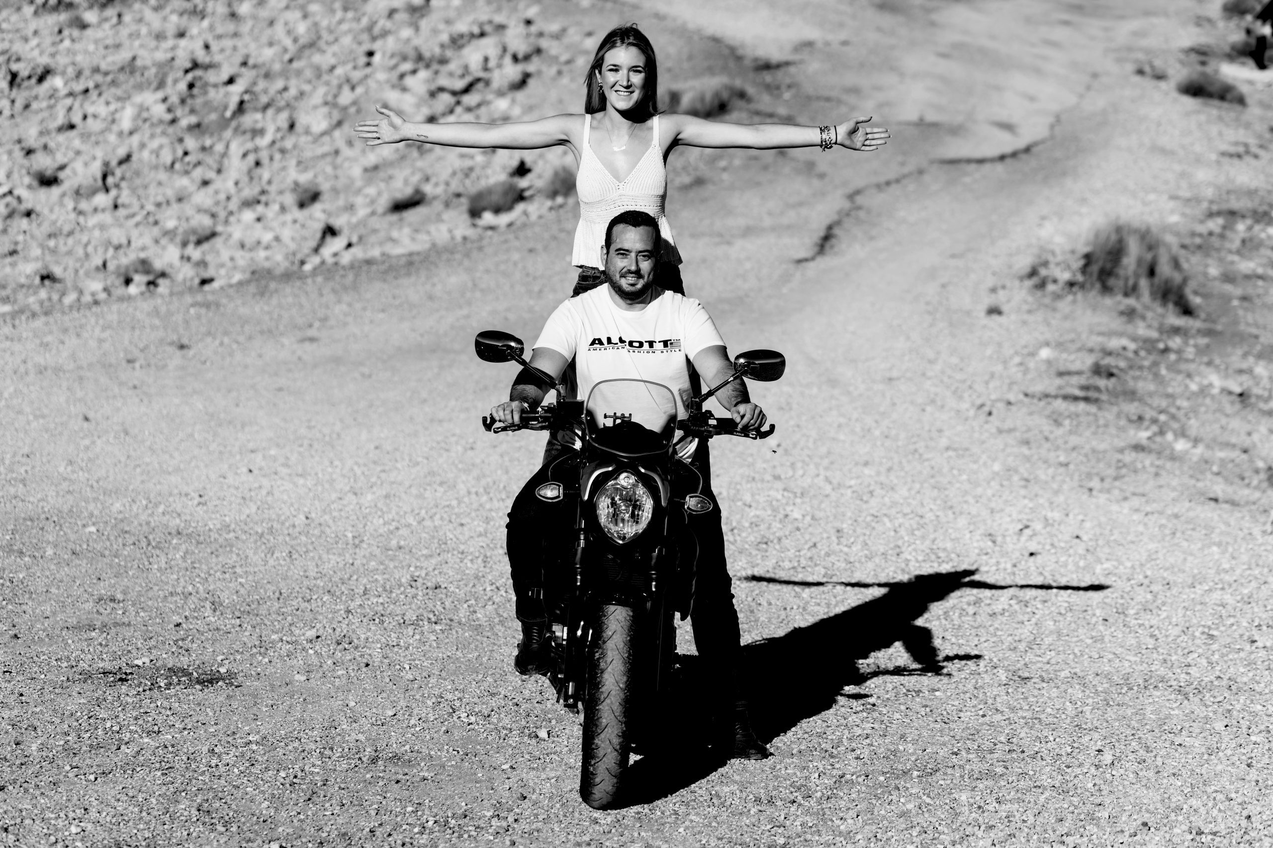 Fotografía en blanco y negro de una pareja encima de una moto