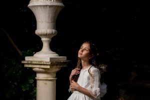 María en su reportaje de comunión junto a una columna, retrato artístico en sombra en Jabalcuz