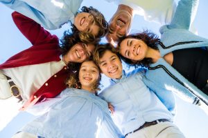 familia en circulo sonriendo mirando a camara desde abajo